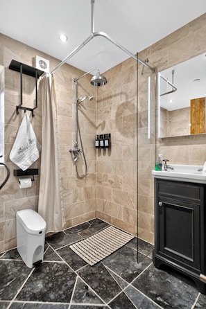 A modern bathroom with a glass-enclosed shower, a toilet, a sink, and a mirror. - Pansy Lodge, this two-bedroom barn conversion sleeps 6. (Mydroilyn)