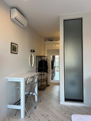 A modern room with a white desk, chairs, a coat rack, and an air conditioning unit. - Beautiful apt. on Svobody avenue 7 Lviv (L'viv)