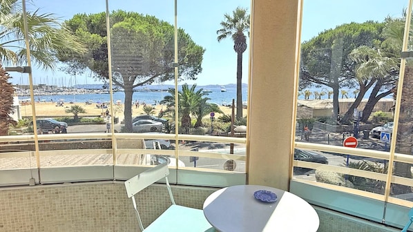 Habitació amb vista a la platja, una taula i cadires.
