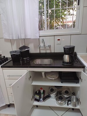 A kitchen with a stainless steel sink, a coffee maker, and various pots and pans. - New Listing (Porto Alegre)