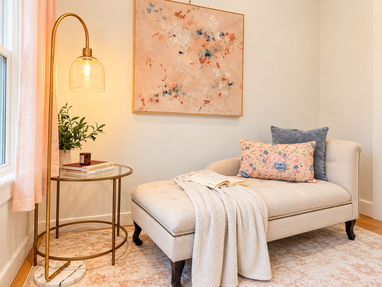 A cozy room with a sofa, a side table with a lamp, a plant, and a painting on the wall.