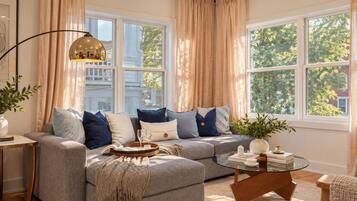 A modern living room with a sectional sofa, a glass coffee table, and a floor lamp.