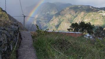 Un sentier qui mène à un paysage montagneux, avec un arc-en-ciel en toile de fond.