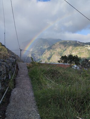 A pathway leading to a mountainous landscape with a rainbow. - New Listing (Tabua)
