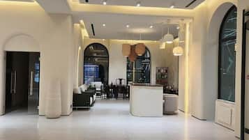 Um interior moderno com balcão de recepção, área de estar e amplas janelas.