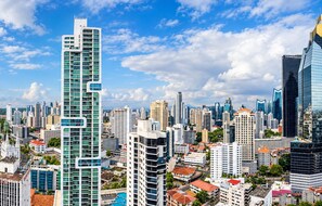 A cityscape with modern high-rise buildings, including a prominent tower with a unique design. - Cozy 1-bedroom apartment in perfect Panamá with AC and gym access (Panamá)