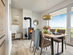 Ein modernes Interieur mit Essbereich, Kamin und Blick durch große Fenster.