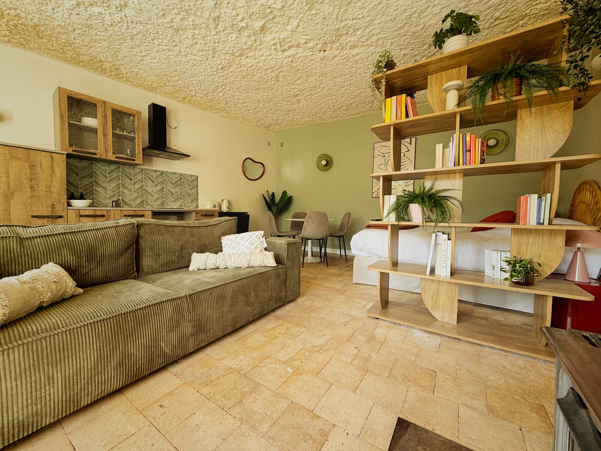 Un salon comprenant un canapé, une table basse, une bibliothèque et un coin repas avec des chaises.
