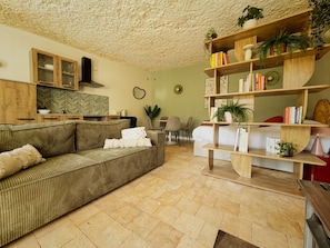 A living room with a sofa, a coffee table, a bookshelf, and a dining area with chairs. - New Listing (Vouvray)