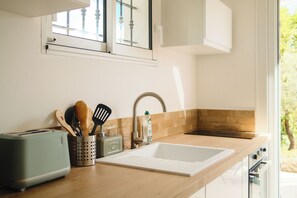 A kitchen with a sink, a toaster, and wooden utensils. - New Listing (Fayence)