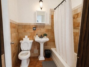 A bathroom with a toilet, sink, and bathtub. - Lexington studio (New York)