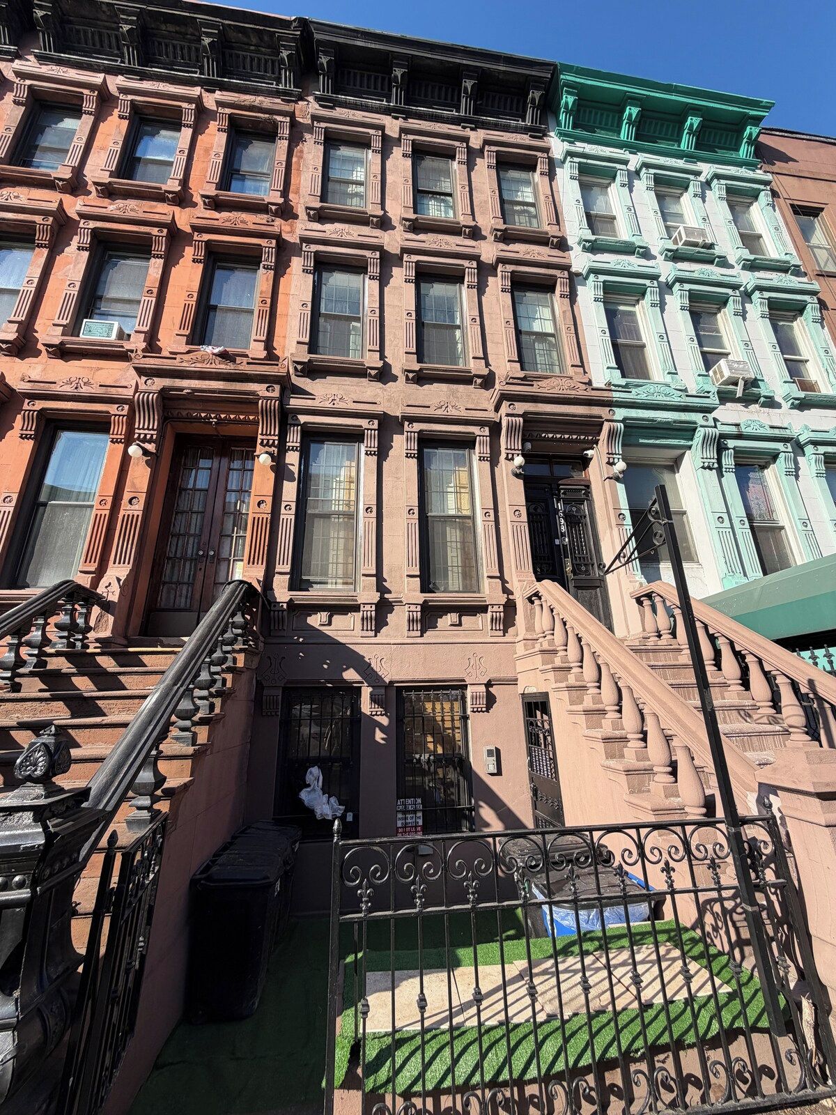 A multi-story building with a fire escape and a gated entrance.