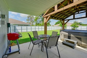 An outdoor patio with a grill, chairs, and a table. - Sun 'n Lake Kozy Korner - Private Hot Tub & Pets Welcome (Sebring)