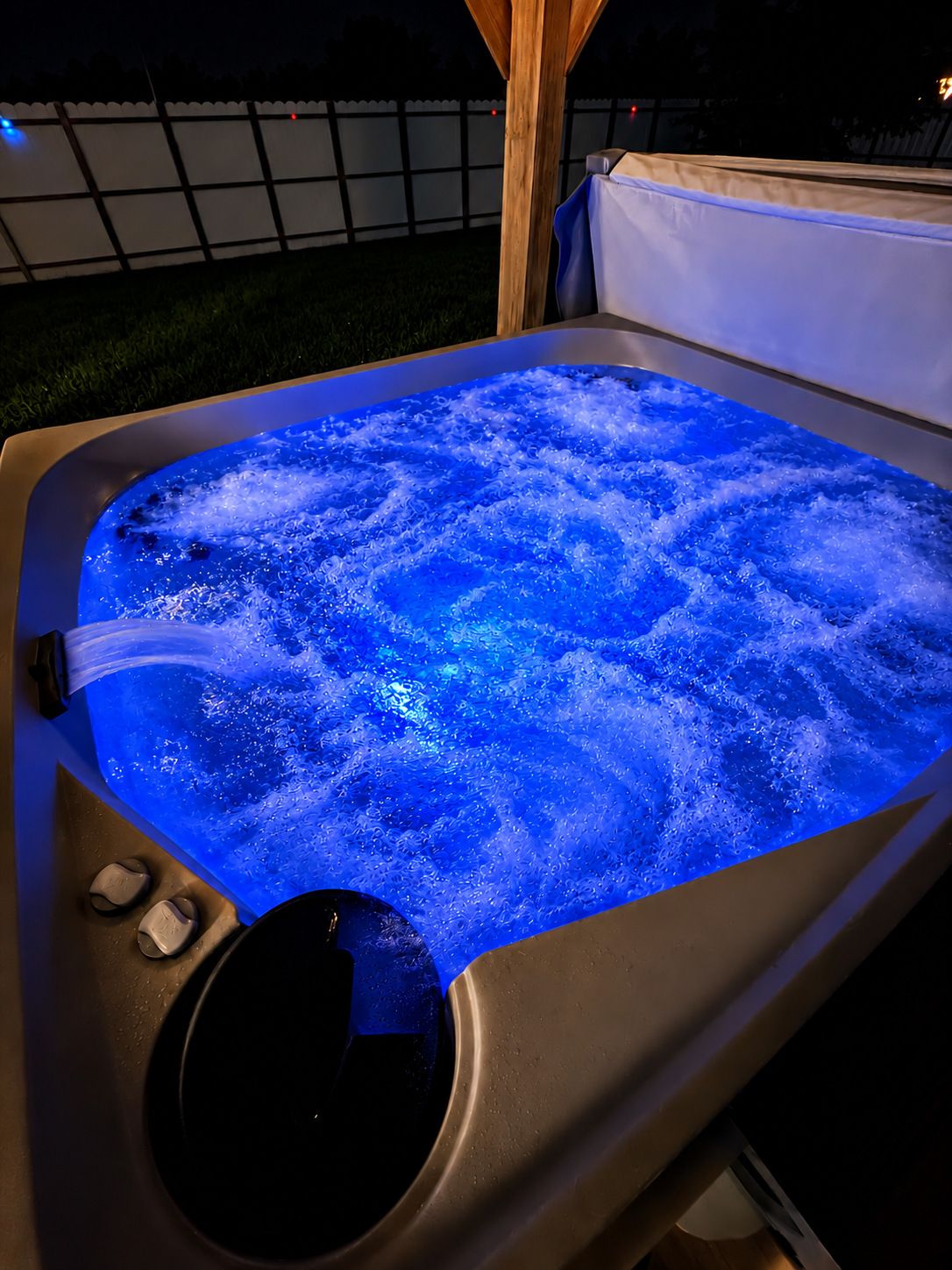 Un jacuzzi con estructura de madera y cubierta blanca.
