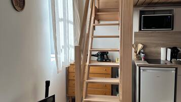 A modern kitchen with a built-in microwave, a coffee machine, and a refrigerator.