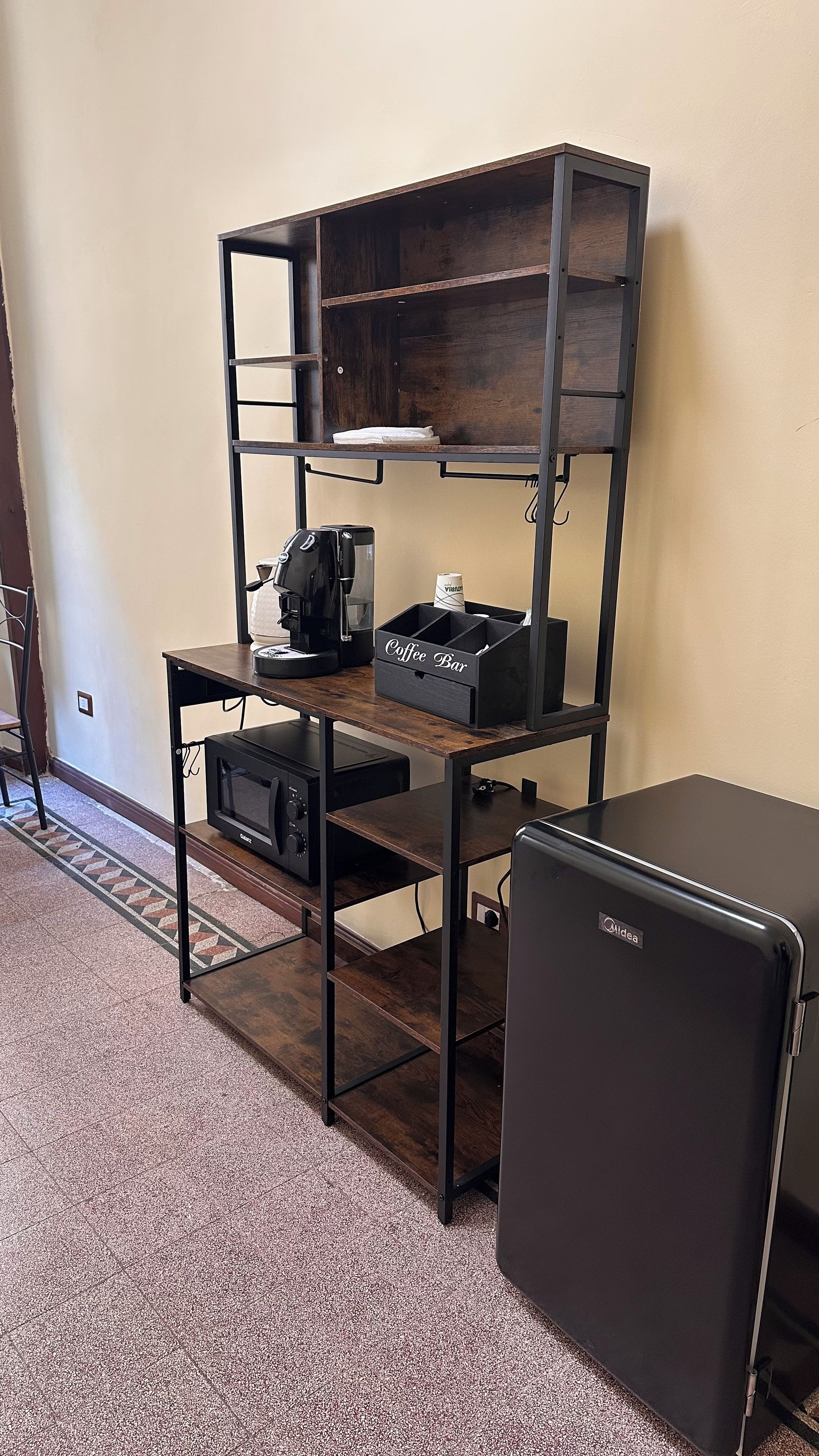 Une petite cuisine équipée d’un four à micro-ondes, d’une machine à café et d’un réfrigérateur.