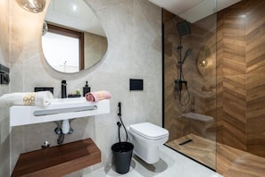 Een moderne badkamer met een wastafel, toilet en douchehoek.