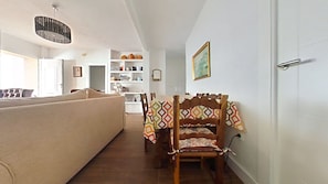A cozy living area with a sofa, a dining table with chairs, and a kitchen in the background. - New Listing (Cabo de Palos)