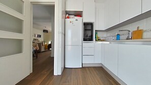 A compact kitchen with white cabinets, a Bosch refrigerator, and a microwave. - New Listing (Cabo de Palos)