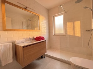 A bathroom with a wooden vanity, a large mirror, a shower, and a toilet. - Clube Praia da Rocha Apartments by Agsuites (Portimão)