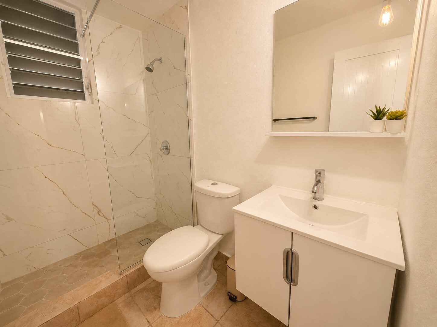 A bathroom with a shower, toilet, and sink.