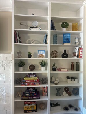 Ein Bücherregal mit verschiedenen Büchern, Dekoration und einer Uhr.