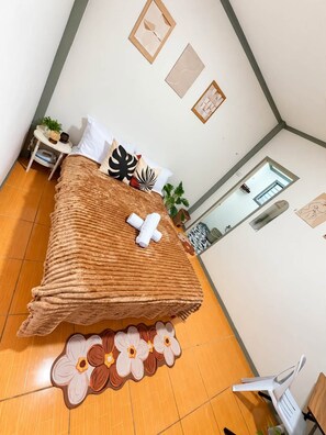 A room with a bed, a small table with a plant, and a window. - Lovely 1-bedroom house in Moalboal perfect for a relaxing getaway (Moalboal)