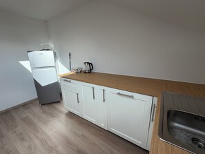 A kitchen with white cabinets, a wooden countertop, and a stainless steel sink. - New Listing (Lonnerstadt)
