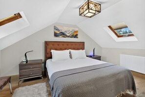 A bedroom with a large bed, a nightstand, a dresser, a radiator, and a ceiling light fixture. - Snowdrop Lodge, this two storey, charming barn conversion sleeps 4 . (Mydroilyn)