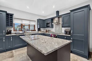 A modern kitchen with dark cabinetry, a granite countertop island, and stainless steel appliances. - Snowdrop Lodge, this two storey, charming barn conversion sleeps 4 . (Mydroilyn)