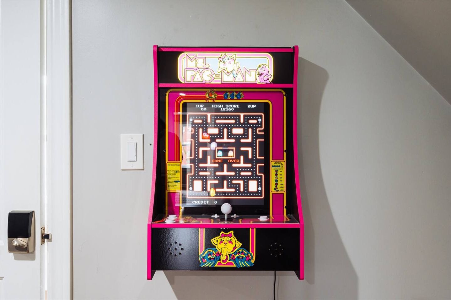 A Pac-Man arcade game machine mounted on a wall.