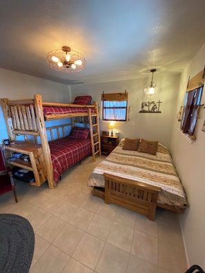 Un dormitorio con una cama individual doble, un escritorio, una lámpara y un candelabro.