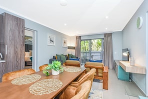 A modern living room with a dining table, sofa, and a small kitchen area. - Luxury Executive Stay  Hurlingham Sandton (Sandton)