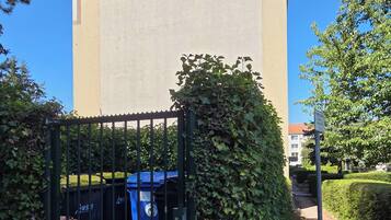 Un edifici amb entrada tancada per una reixa, cel blau i un camí que hi condueix.