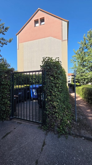 Ein Gebäude mit einem Eingangstor, blauem Himmel und einem Weg, der dorthin führt.