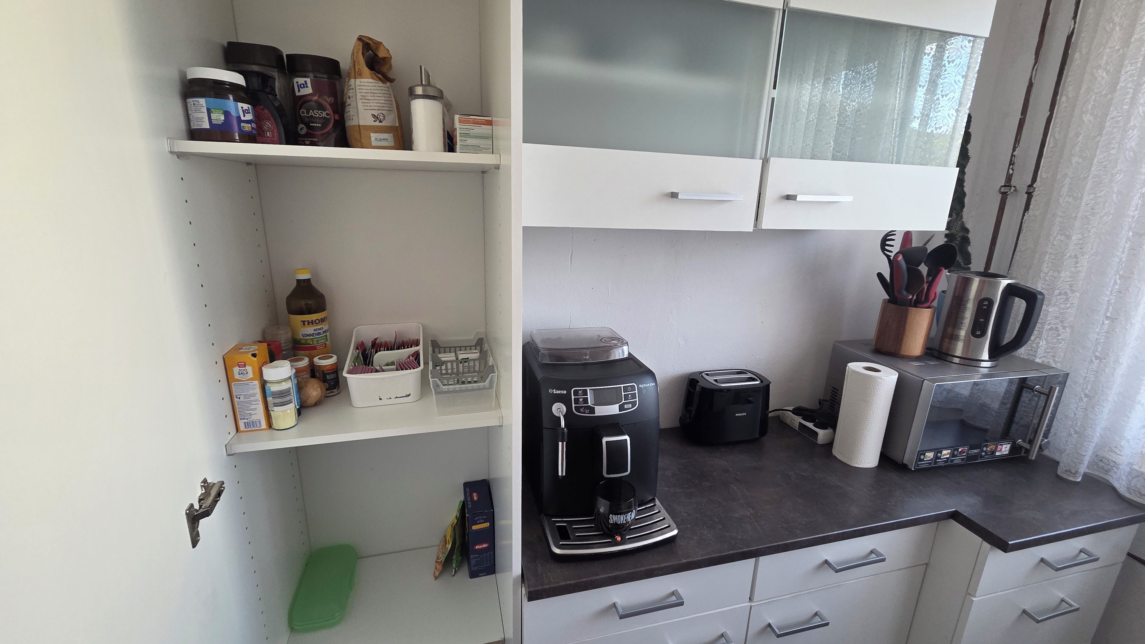 Eine Küchenzeile mit einer Kaffeemaschine, einem Toaster und einem Wasserkocher auf der Arbeitsfläche.