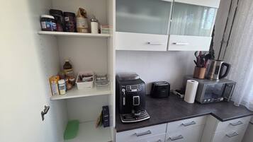 Una cuineta amb cafetera, torradora i bullidor a la barra.
