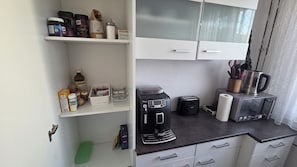 Eine Küchenzeile mit einer Kaffeemaschine, einem Toaster und einem Wasserkocher auf der Arbeitsfläche.