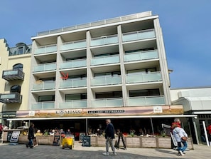 A multi-story building with a cafe, bar, and restaurant on the ground floor. - Holiday Apartment With 1 Bedroom (Sylt)