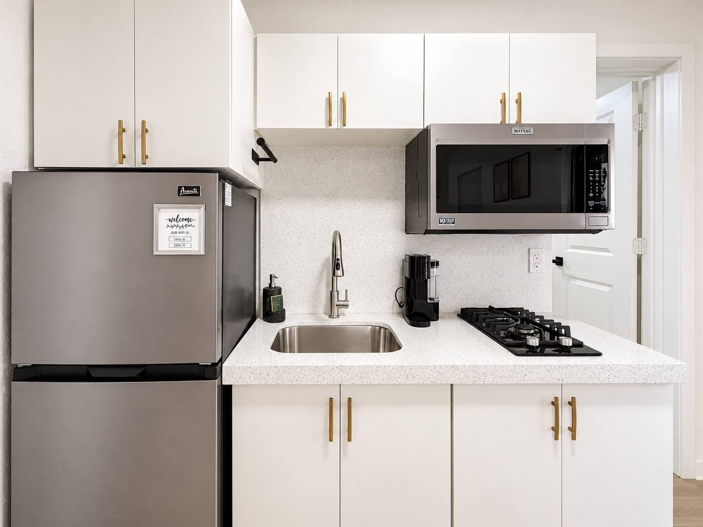 Una cocina moderna con electrodomésticos de acero inoxidable, un microondas integrado y una estufa a gas.