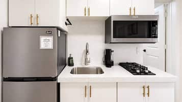 Una cocina moderna con electrodomésticos de acero inoxidable, un microondas integrado y una estufa a gas.
