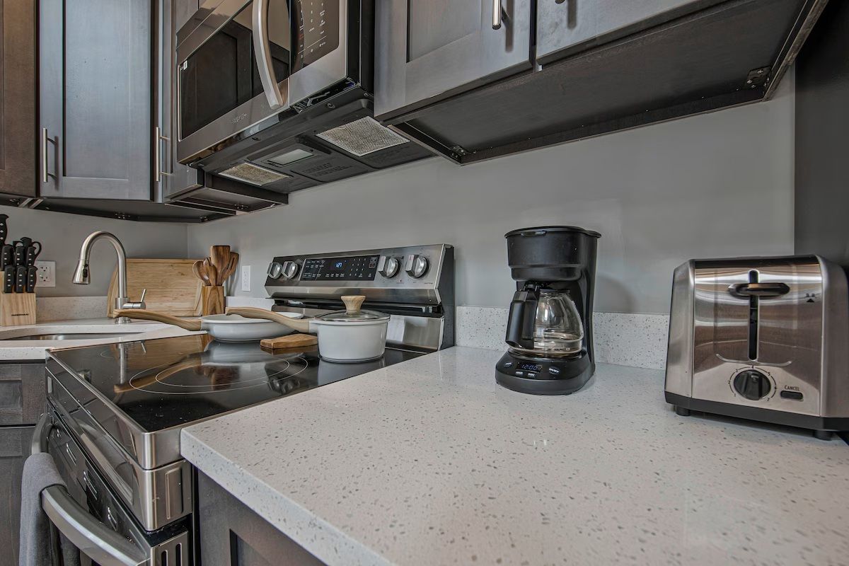 A modern kitchen with stainless steel appliances, including a stove, microwave, and toaster.