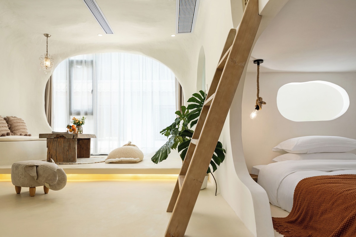 A modern bedroom with a large window, a bed, a bedside table, and a hanging light fixture.