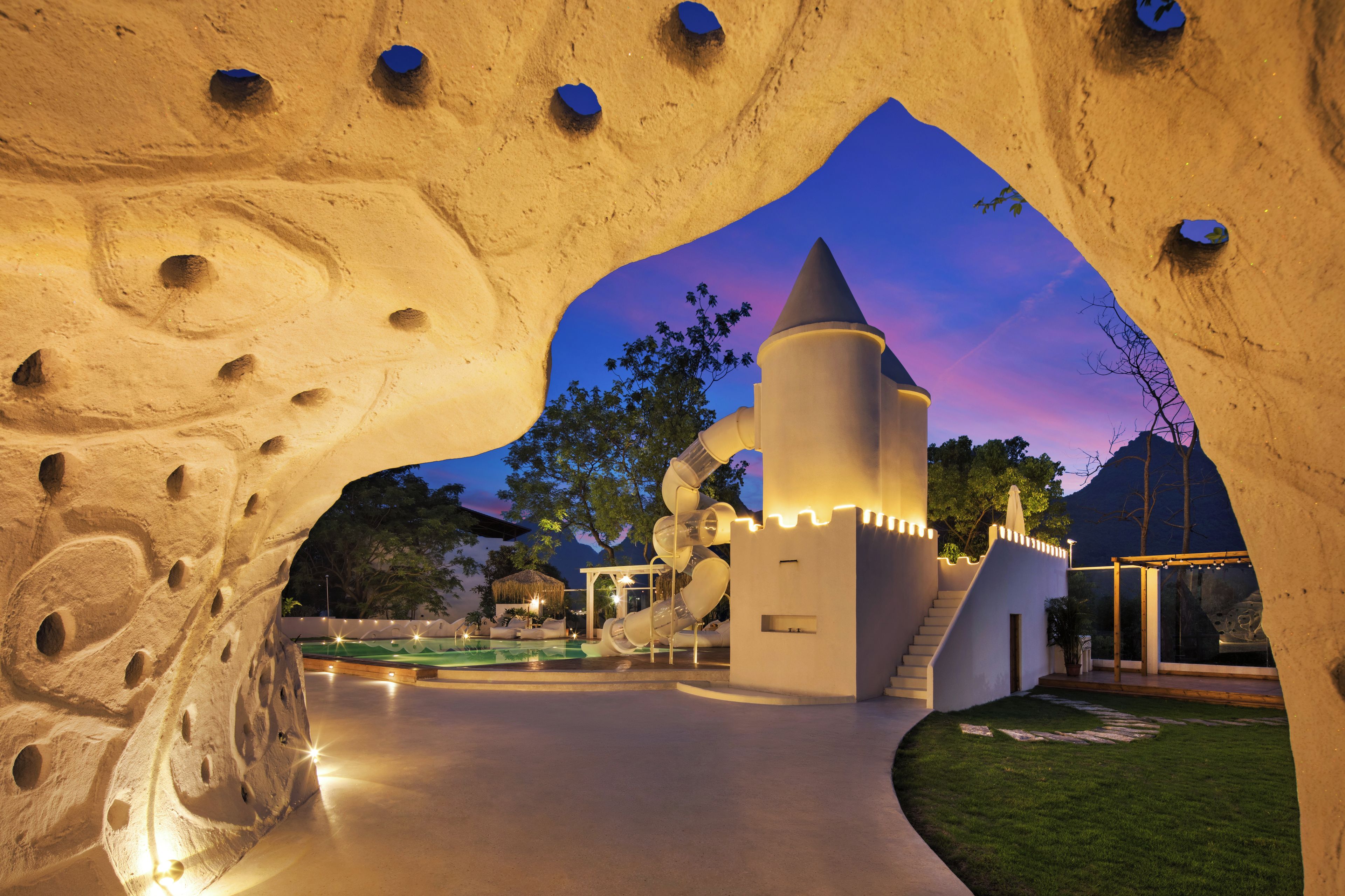 A castle-like structure with a water slide and a pool area.