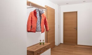 Une pièce avec une armoire en bois, une commode en bois et une porte.