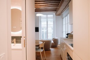 Una cocina moderna con comedor, suelo de madera y un amplio ventanal que proporciona luz natural.