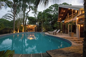 A swimming pool with lounge chairs and a covered area with string lights. - Dragonfly Villa - By Zenbreak (Holetown)
