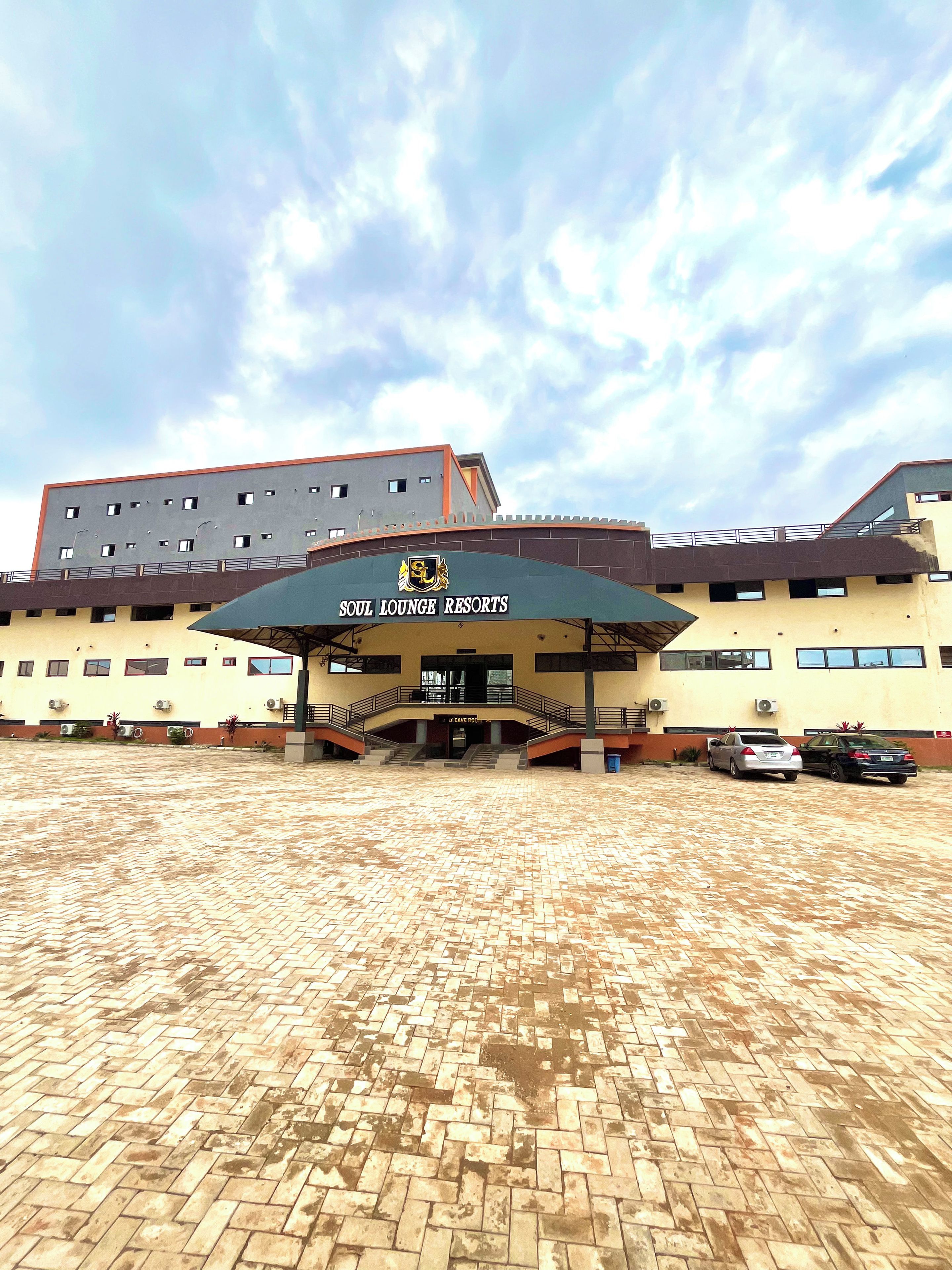 A building with a sign reading 'Soul Lounge Resorts' and a paved area in front.