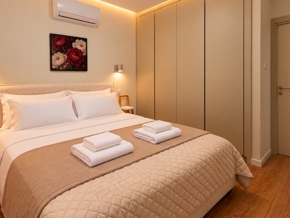 A hotel room with a bed, a bedside table, an air conditioning unit, a wall-mounted light, and a door. - River Plaza Apartment (Limassol)