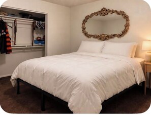 A bedroom with a bed, a wardrobe, and a mirror on the wall. - 2-bedroom apartment in excellent Phoenix with refreshing AC (Phoenix)